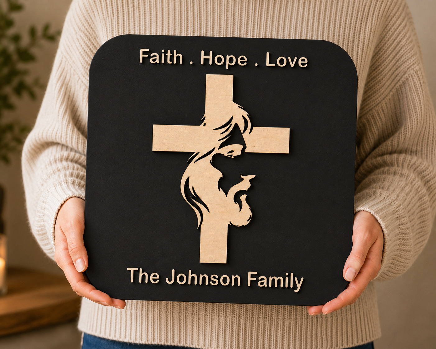 Hands holding the handcrafted Cross of Faith Plaque featuring a cross with the silhouette of Jesus Christ, personalized family name, and layered premium wood craftsmanship.